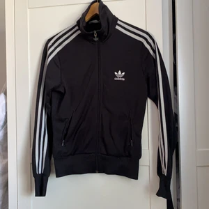 Adidas track jacket - Fint skick, använd, har reparerats en gång i ärmen (se bild). Det märks inte när den sitter på. Fraktas mot fraktkostnad eller avhämtas i Märsta. 