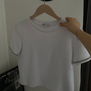 Zara topp  - Säljer denna snygga t-shirt men fina detaljer på armarna från Zara, lite tjockare i materialet, liten i storleken, skulle säga att den sitter som en S💕🥺