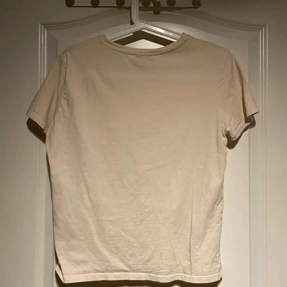 Beige T-shirt med fastsytt tryck på framsidan från zara. Köparen står själv för frakten. T-shirts.