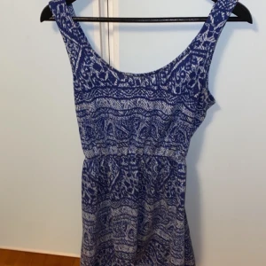 Sommarklänning  - Köpte klänningen i somras, ha aldrig använt den. Det är en blå/vit klänning med öppen rygg. Väldigt fin och är i bra skick.
