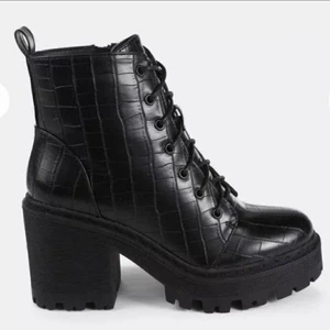 Missguided 38 croc boots killstar - Säljer ett par riktigt feta boots/kängor från Missguided, stl 38. Går även med 38,5. Använda några få gånger, se sista bilden för "slitage". De fläckar som syns går att putsa bort ✨ Säljes pga platsbrist. Bekväma att gå i. Passar bra med en del övriga plagg bland mina annonser, gå och kika 🤙 Köparen står för frakten. Men jag är inte omöjlig. Pussokram 🖤