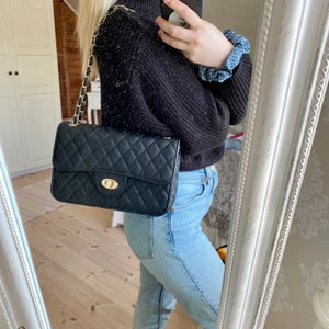 Svart väska  - Svart väska med gulddetaljer. Väldigt rymligt. Använd fåtal gånger så är i väldigt fint skick. !Det är spegeln som är smutsig inte väskan! 70kr+frakt 