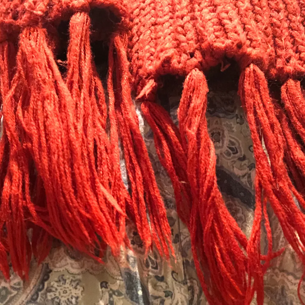 Klassisk stickad röd halsduk. Lång nog att vira två varv. Mjuk och varm! . Stickat.