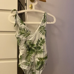 Body - En snygg body med växt-mönster! Man kan justera storleken något med snörena man knyter uppe på axlarna. Sitter väldigt snyggt! Perfekt till sommaren.
