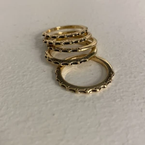 Ringar - Säljer dessa guldiga och svarta ringar.❤️ Det är 5 stycken och man köper dom alla tillsammans. Dom är i nickel. Ringarna är för stora för mina fingrar och kommer därmed inte till användning. Aldrig använda. Köpare betalar frakt❤️ pris kan diskuteras❤️