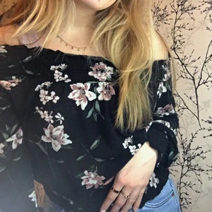 Off shoulder topp - Superfin, svart off shoulder topp med blommigt mönster i strl XS men som även passar en strl S. Toppen har resår vid axlar, handleder och mage. Den är lite nopprig men är i ett mycket bra skick. Fraktalternativ: 66kr spårbart eller frimärken. Meddela mig vid fler frågor!😊