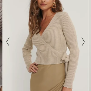 Skitsnygg stickad tröja från NA-KD - Superfin beige ribbstickad omlotttröja i god kvalitet!💗                                          Köpt för 400kr och aldrig använd då den tyvärr är för liten.              Storlek 38 men skulle säga att den är mer en 36a!