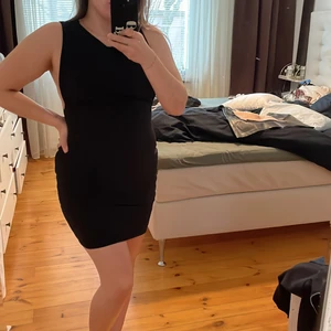 Fodralklänning Nelly  - Svart fodralklänning i lite skimmrigt material med ”Sideboob”. Aldrig använd och lappar kvar. Pris exkl frakt 