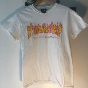 Vit Thrasher Flame T-Shirt i storlek S passar även XS. Fint plagg men trycket har hunnit bli lite slitet. Nypris ligger på 450 kr. 