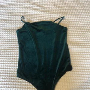 Body  - En grön body i sammet. Använd 1 gång, i bra skick. Från Bik Bok. Köpare betalar frakt.