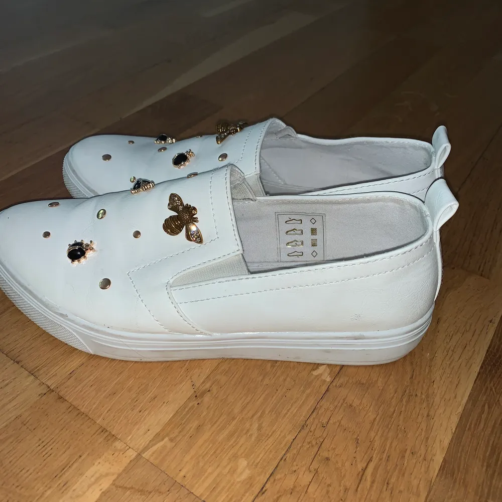 Vita slip on skor med fina våriga dekorationer 😋. Skor.