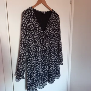 Söt svart klänning med tusenskönor - Söt svart klänning med vit och gula tusenskönor. Babydoll fit. Använd en gång. Storleken som står är xxs men den passar mig som är en S/M.