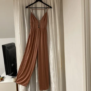 Asos petite jumpsuit siden dirty pink  - Siden dirty pink jumpsuit i storlek 34 petite. Använd några gånger men i bra skick. Frakt tillkommer. Vid intresse fråga gärna efter fler bilder.