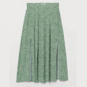 Grön blommig kjol - Säljer denna supersöta kjol jag köpte på h&m i somras! Nästan oanvänd och är som ny! Den är grön med vita blommor med två slitsar på sidorna 💗