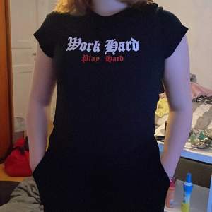 En svart T-shirt med trygg på bröstkorgen
