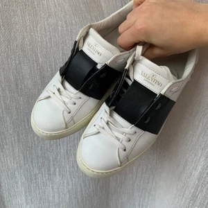 Valentino sneakers strl 36 - Säljer nu mina vita Valentinos med svart detalj. Storlek 36 & passar mig som vanligtvis har 37. Det är stora i storleken! I fint skick! Kom med egna bud. Box och finns kvar om man vill ha med. 