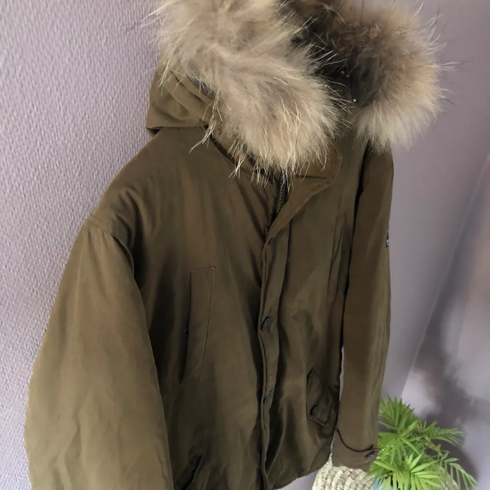 Olive Green winter jacket, from “Le Temps des cerises”, size: L  In very good condition, only used a couple of times.  Original price : 2 000 kr  (P.S. real raccoon fur). Jackor.