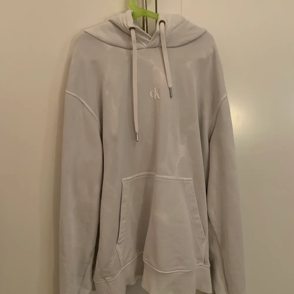 En Calvin klein hoodie i storlek M med ett tryck på ryggen. Den är i färgen grå och är lite vitspräcklig så den får en snygg marmor effekt. Hoodies.