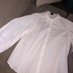 En vit skjorta med puffiga armar i storlek 42. Helt oanvänd då den är för stor för mig. Köptes för 299kr. Kan skickas men då står köparen för fraktkostnader.