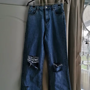 Utsvängda blå jeans - Helt nya högmidjade blåa jeans med hål på knäna. Är från Shabby Chic på Boohoo. 28 tum i midjan. Meddela om ni vill ha fler bilder/har frågor<3