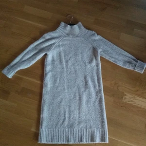 Stickad klänning - En stickad poloklänning från H&M. Den är ljusgrå och liten längre än knäna på mig (168 cm). 