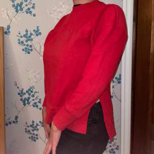 Långärmad röd tröja med slits på båda sidorna