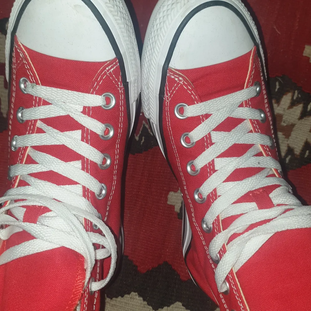 Ett par röda hi-top converse som blivit använda två gånger. Har lite märken på de vita delarna men knappt märkbart.. Skor.