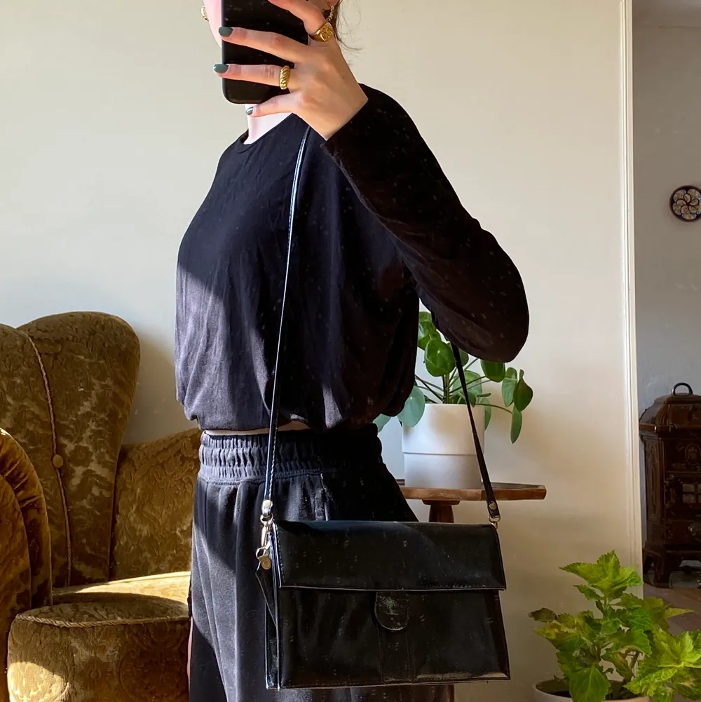 svart, axelbandsväska med gulddetaljer och smidigt lås. vintage modell köpt på second hand. . Väskor.