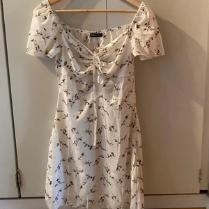 Blommig klänning - Vit klännning med blommor från Shein. Den har aldrig använts, endast provad. Kan mötas i Stockholm eller skicka. Frakt: 66kr spårbart 💗