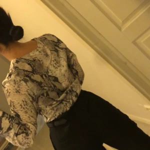 NA-KD blus snakeprint - Blus med snakeprint från NA-KD, perfekt för våren. Blusen har vida långa ärmar.