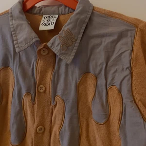 Drop dead kofta - Cool kofta/tröja från Drop Dead. Har ett droppmönster överst. Stylas gärna med en liten väst över till ett par bootcut byxor för en lite fairygrunge aktig look. Är i en senapsgul färg. Fri frakt!