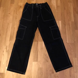Svarta byxor från Urban Outfitters - Svarta cargo pants från Urban Outfitters. Storlek 30/32