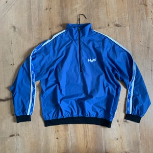 H2O windbreaker  - Cool vintage windbreaker från H2O i storlek L. Har använt både som jacka med hoddie under och som tröja och knutit in den i midjan. Tunt material som är vindtätt! 