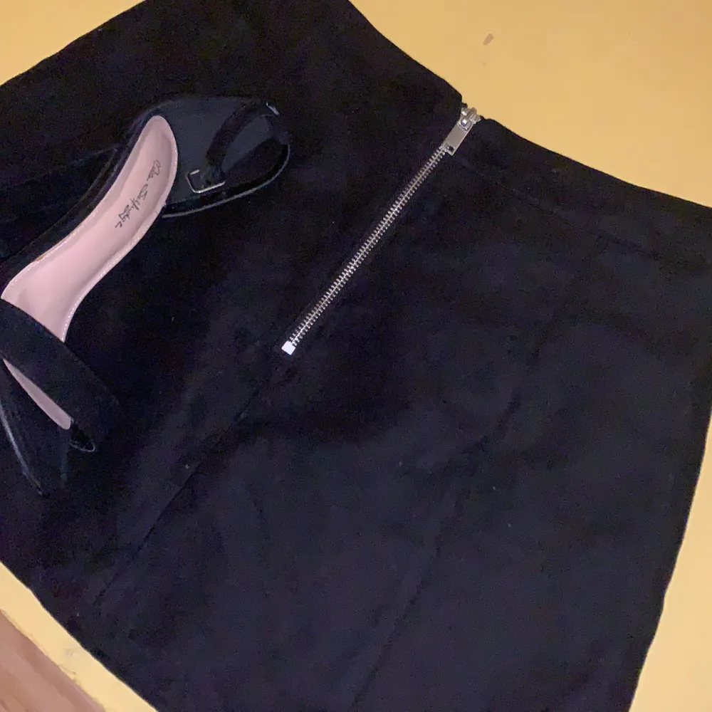En svart kjol med dragkedja fram. En tajt passform och kort längd. Använd ett fåtal gånger och är i bra skick🍸. Kjolar.
