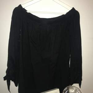 Off shoulder tröja med svarta rosetter i ärmarna, använd fåtal gånger, köparen står för frakt