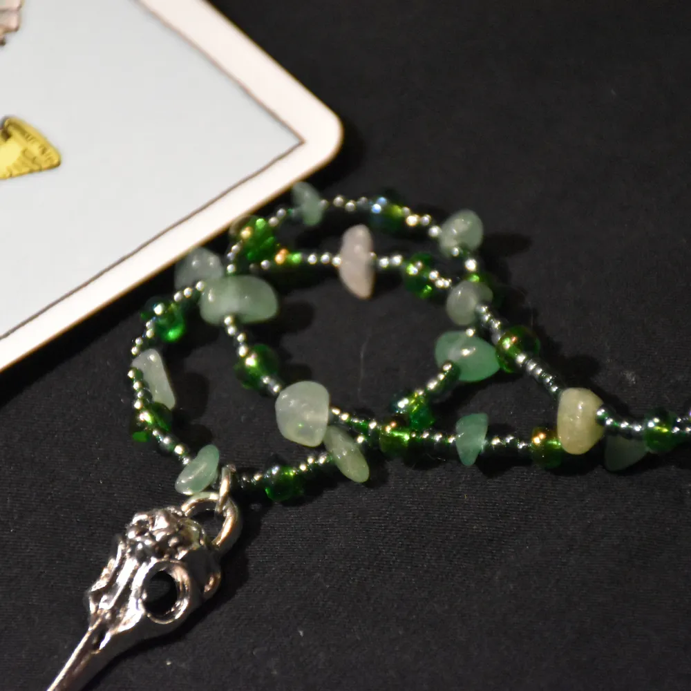 Halsband med en fågelskalle i metall och aventurin med gröna glaspärlor. . Accessoarer.