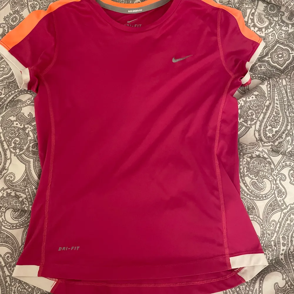 Träningströja från Nike med vita och orangea detaljer, bra skick och sitter fint. Strl xs/s. Frakt tillkommer och hör av dig vid frågor 💕. Hoodies.