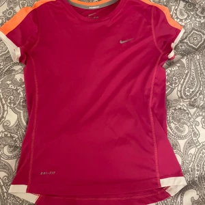 Nike tshirt  - Träningströja från Nike med vita och orangea detaljer, bra skick och sitter fint. Strl xs/s. Frakt tillkommer och hör av dig vid frågor 💕