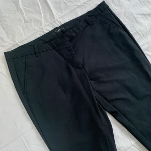 Nya kostymbyxor från Vila/ storlek M-L - Kostymbyxor från Vila i halvstretchigt material, storlek L, men passar även M då de är små i storleken. Avsmalnande modell som stängs med dragkedja i gylf samt hake och knapp. Fickor framtill. Använda en gång, så helt i nyskick. Skriv vid frågor :)