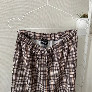 Raka coola byxor från ASOS - Coola byxor inköpta från ASOS men som aldrig använts (tyvärr inte min stil). Byxorna är rutiga, tunna och har en fickdetalj på ena benet med en liten orange färgklick! Märket är New Girl Order.