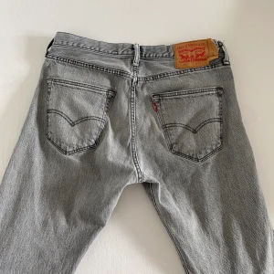 Levi’s 501 - Grå Levi’s jeans köpta second hand men i gott skick. unisex modell, de visas på en kille som är 185👍🏼 fraktar spårbart för 66kr eller möts upp i Malmö! 