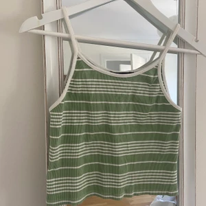 BikBok Grön Crop top Strl L - Grön/Vit-randig Crop top/Linne från BikBok i Strl L. Väldigt liten i storlek, skulle säga att det även passar en M/S. Knappt använd, så i mycket bra skick! Pris exklusive frakt💛