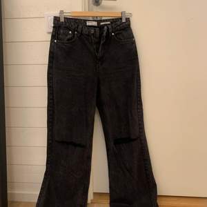 Oanvända svarta jeans med hål vid knäna från Berchka. Storlek 38