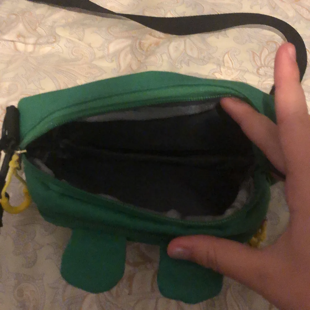 En grön liten väska med ett ansikte av en groda, aldrig använt :) väldigt gullig! . Väskor.