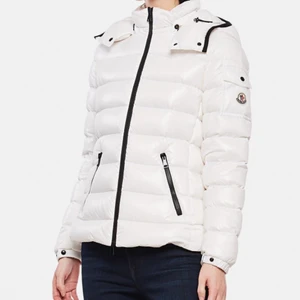 Moncler jacka  - Vit moncler jacka dam med svarta detaljer stl. 0 (34). Den är i fint skick och endast använd en vinter. Nypris 10.000. Skriv privat för fler bilder eller för mer information. Köparen står för frakten. 