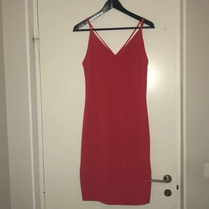 Röd klänning - Tajt snygg klänning som går till knät. Öppning på sidorna. Bild 2 är ryggen. Aldrig använd. Strl xs men passar S/M