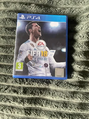 FIFA 18 till PS4 - Säljer FIFA 18 till PlayStation 4. Spelet kommer i ett blått plastfodral med omslag där en fotbollsspelare syns. Skivan är svart med vita och gula detaljer och har PS4-loggan. Perfekt för dig som gillar fotbollsspel och vill utmana kompisarna hemma.