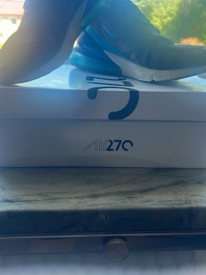 Nike Air Max 270 Gym Red/White - Nike Air Max 270 sneakers i färgen gym red, vitt och svart. Skorna har en modern siluett med synlig Air-enhet i hälen och en sportig vibe. Ovandelen är i mesh och syntetmaterial med klassisk Nike-logga på sidan. Perfekta för dig som gillar streetwear och sneakers med attityd.