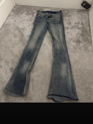 Blå utsvängda jeans från weekday cheep Monday  - Säljer ett par blå jeans med utsvängda ben och snygga slitningar. Cheep Monday jeans som är använda max 7 gånger kanske, så de är väldigt bra skick på dom och de är storlek 27/32