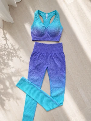 Turkos-lila träningsset ombre - Snyggt träningsset med sport-bh och tights i ombre färgskala från turkos till lila. Setet är sömlöst och tillverkat i en mjuk blandning av polyester, nylon och spandex för maximal komfort och stretch. Perfekt för gymmet eller yoga.